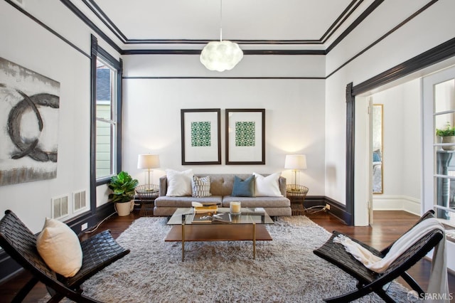 living room featuring ornamental molding and dark hardwood / wood-style floors