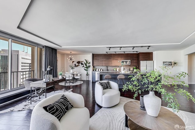 living area featuring dark wood finished floors and an inviting chandelier