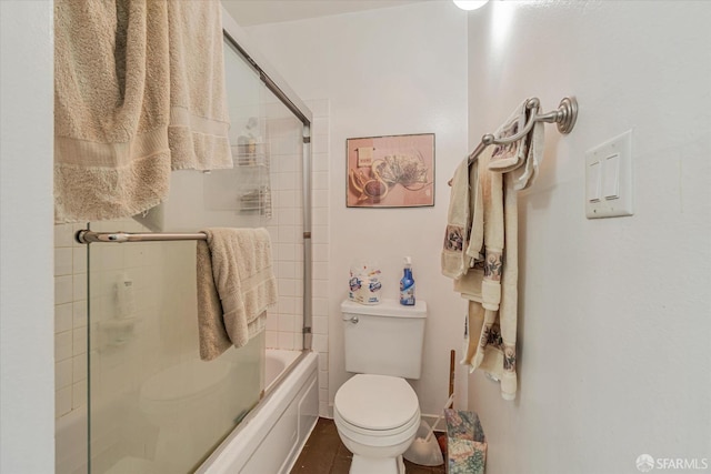 bathroom with combined bath / shower with glass door and toilet