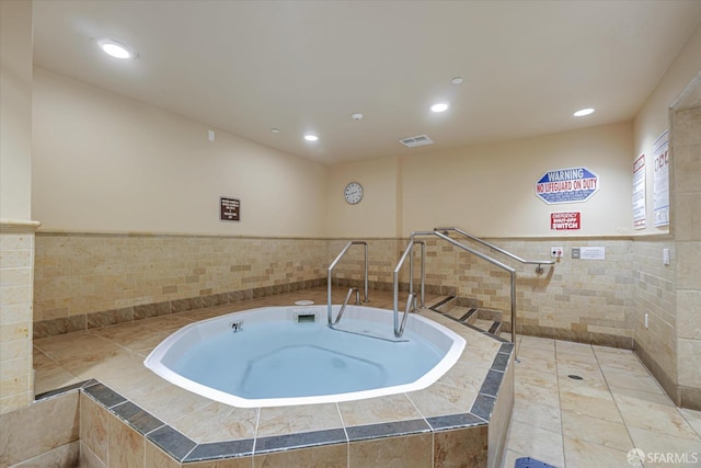 view of swimming pool with an indoor hot tub