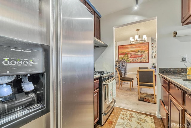 kitchen with dark stone countertops, pendant lighting, a chandelier, light carpet, and appliances with stainless steel finishes