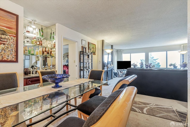 dining room featuring carpet and a textured ceiling