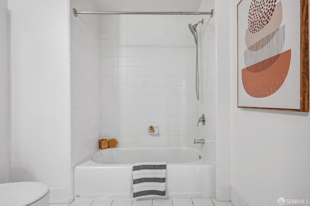 bathroom with toilet, tiled shower / bath combo, and tile patterned floors