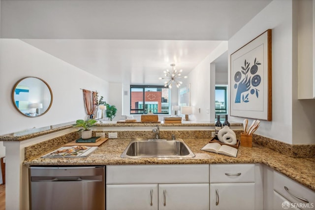 kitchen with a chandelier, sink, white cabinets, stainless steel dishwasher, and kitchen peninsula