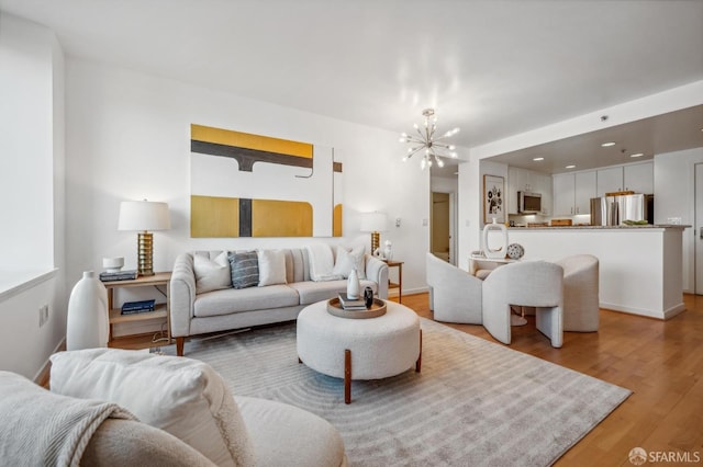 living room featuring light wood-type flooring and a chandelier