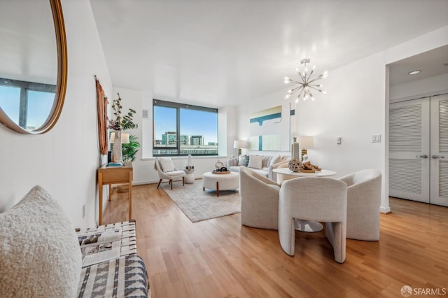 living room with light hardwood / wood-style floors and an inviting chandelier