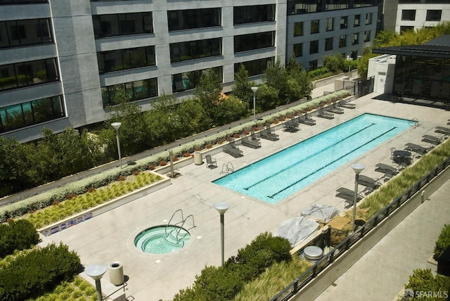 view of swimming pool with a hot tub and a patio area