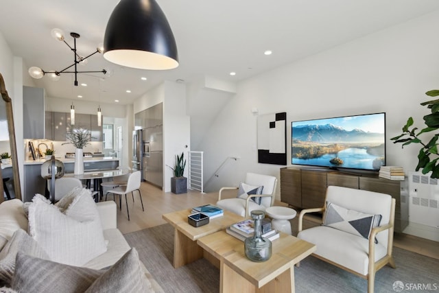 living room featuring light wood-style floors, a notable chandelier, and recessed lighting