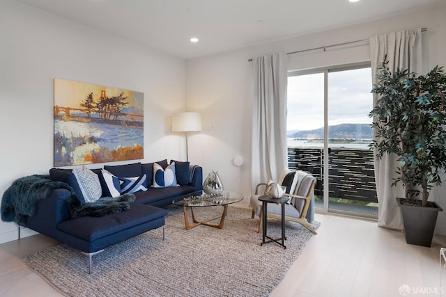 living room with hardwood / wood-style flooring and a water view