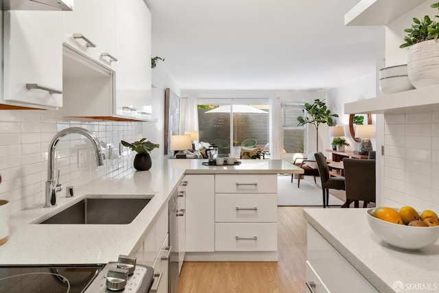 2364 Pacific Ave Unit 3, San Francisco, CA 94115 - kitchen with a sink, light wood finished floors, white cabinetry, and tasteful backsplash