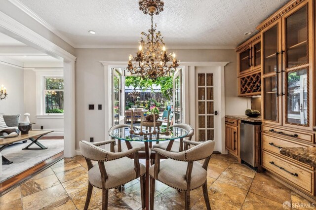 68 Castro St, San Francisco, CA 94114 - dining area featuring a chandelier, stone tile floors, a textured ceiling, baseboards, and crown molding
