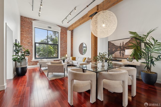 dining room featuring brick wall, wood-type flooring, visible vents, and beam ceiling