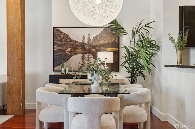 dining area with baseboards and wood finished floors