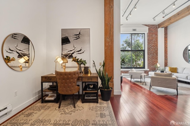 office area featuring baseboards, hardwood / wood-style floors, a baseboard radiator, and ornate columns