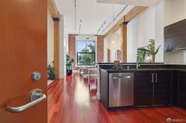 kitchen featuring brick wall, stainless steel dishwasher, dark wood-style flooring, and a sink