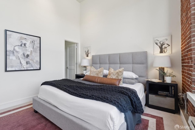 carpeted bedroom featuring a high ceiling and baseboards