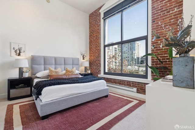 bedroom featuring carpet floors, brick wall, and baseboard heating