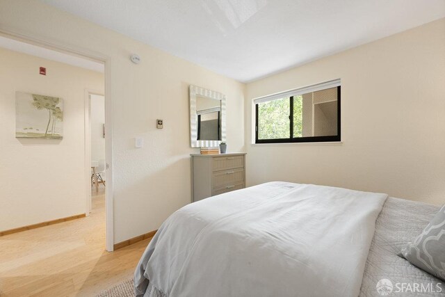 bedroom with light wood-style floors and baseboards