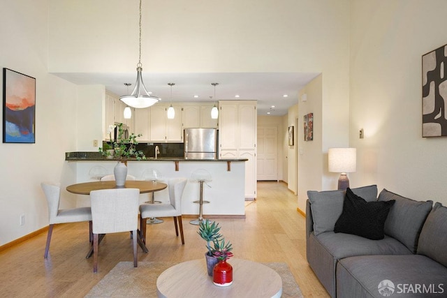 living area featuring recessed lighting, light wood-style floors, and baseboards