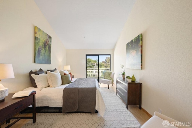 bedroom with lofted ceiling and light wood-style flooring