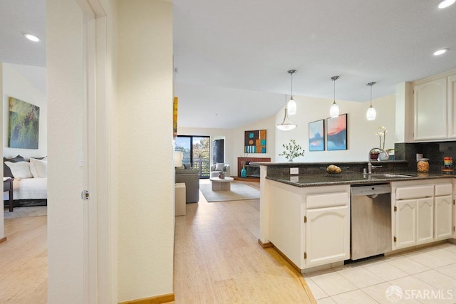 kitchen with vaulted ceiling, stainless steel dishwasher, a sink, a peninsula, and open floor plan