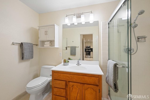 full bathroom with toilet, tile patterned floors, a stall shower, vanity, and baseboards