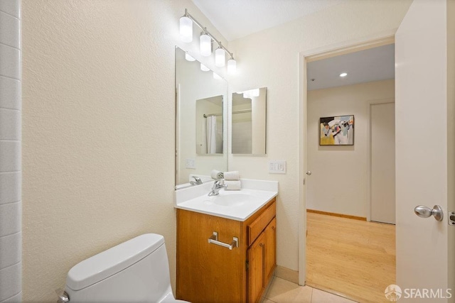 bathroom with toilet, vanity, and tile patterned floors