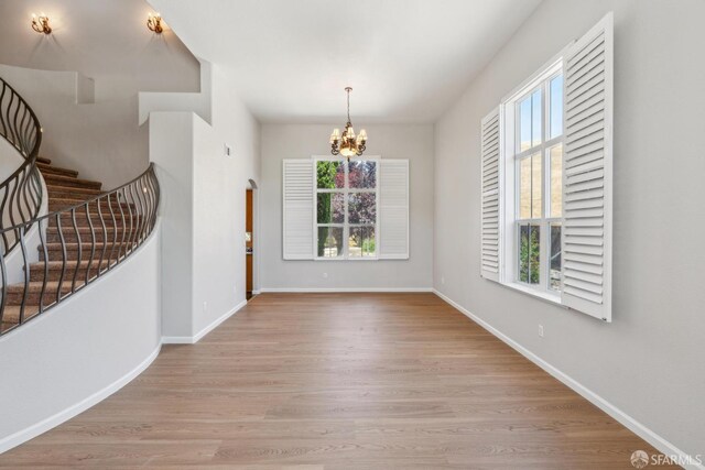 5317 Judsonville Dr, Antioch, CA 94531 - unfurnished dining area featuring a chandelier, stairs, wood finished floors, and baseboards