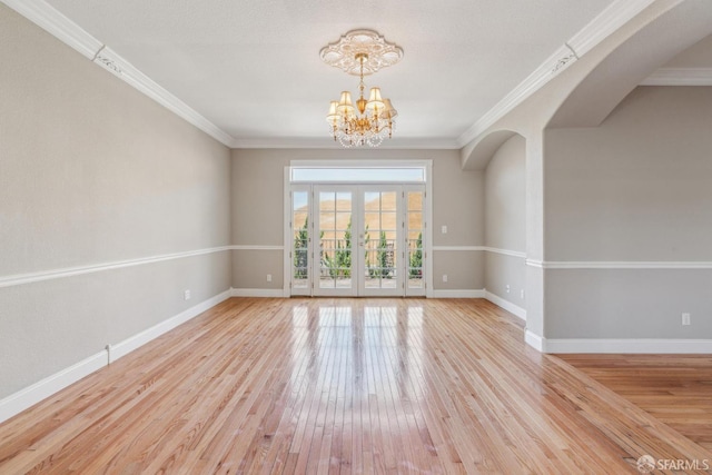5317 Judsonville Dr, Antioch, CA 94531 - spare room featuring a chandelier, baseboards, light wood finished floors, arched walkways, and crown molding