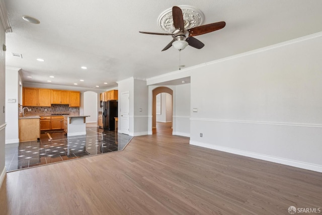 5317 Judsonville Dr, Antioch, CA 94531 - unfurnished living room featuring arched walkways, a ceiling fan, baseboards, dark wood-type flooring, and a sink