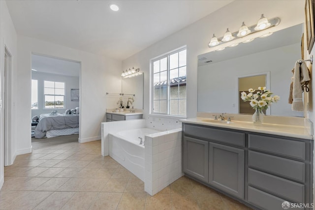 bathroom with vanity, tile patterned flooring, and tiled bath