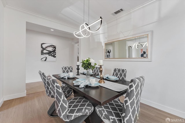 dining space featuring ornamental molding and wood-type flooring