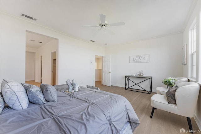 bedroom featuring ceiling fan, crown molding, and light wood-type flooring