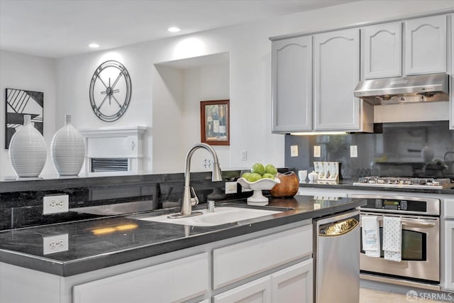 kitchen with stainless steel appliances, sink, white cabinets, light tile patterned floors, and tasteful backsplash