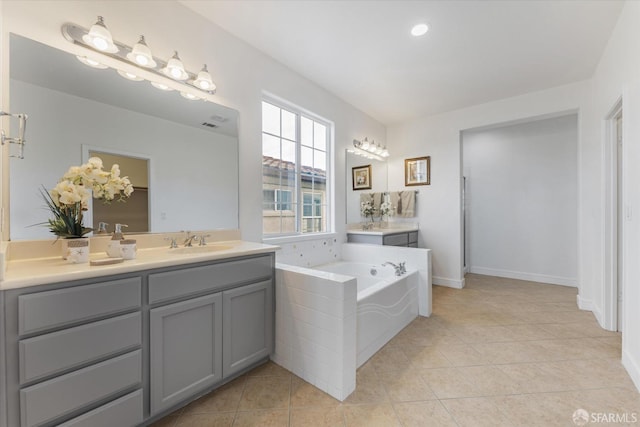 bathroom featuring a bathing tub, tile patterned flooring, and vanity