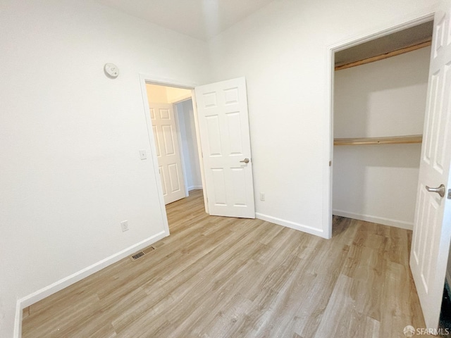 unfurnished bedroom with a closet and light wood-type flooring