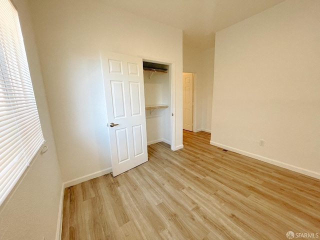 unfurnished bedroom featuring light hardwood / wood-style flooring and a closet