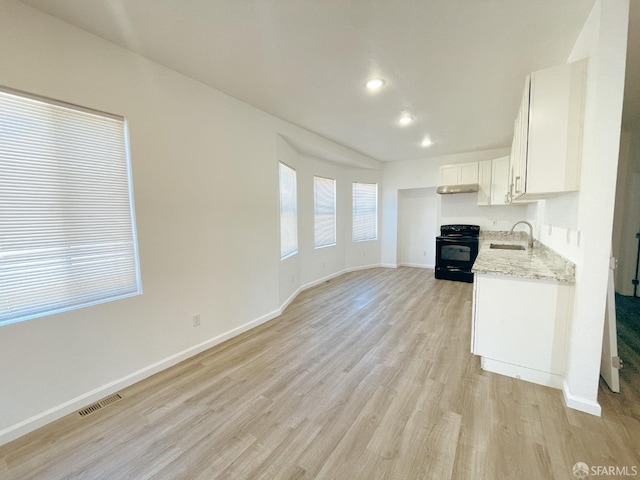 kitchen featuring white cabinetry, sink, light hardwood / wood-style floors, light stone counters, and black range with electric cooktop