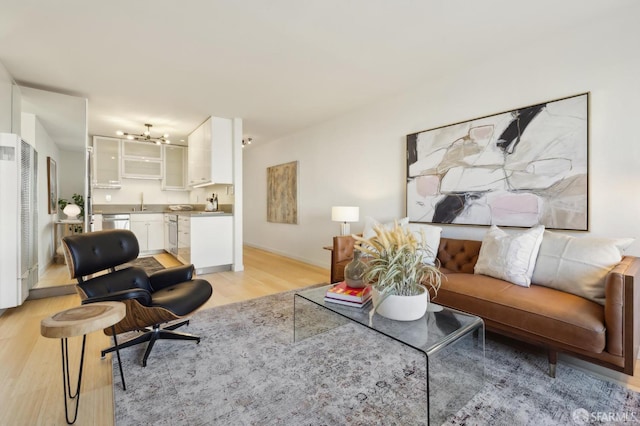 living room featuring sink and light hardwood / wood-style flooring