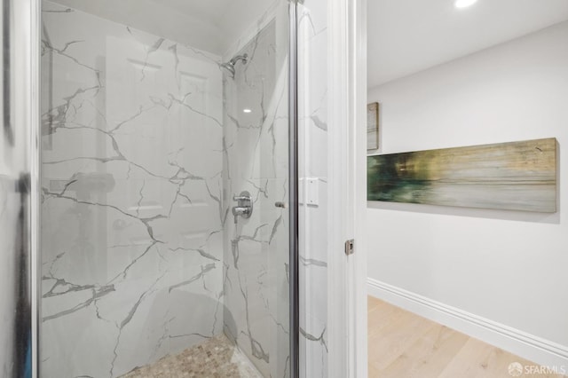 bathroom featuring tiled shower and hardwood / wood-style flooring