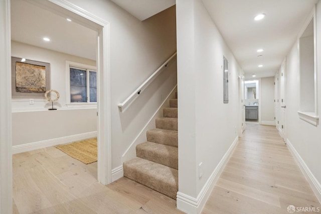 staircase with electric panel and hardwood / wood-style flooring