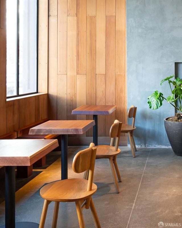 dining space featuring wood walls