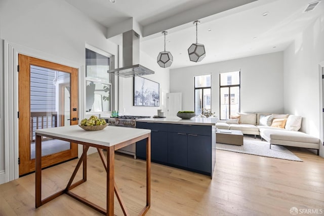 kitchen featuring blue cabinets, stainless steel range, light hardwood / wood-style floors, and island exhaust hood