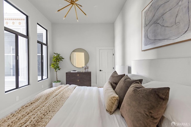 bedroom featuring multiple windows and a chandelier