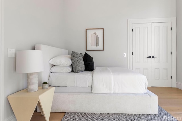 bedroom with light hardwood / wood-style flooring and a closet