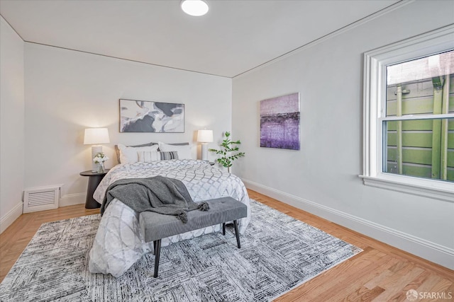 bedroom featuring visible vents, light wood-style flooring, and baseboards