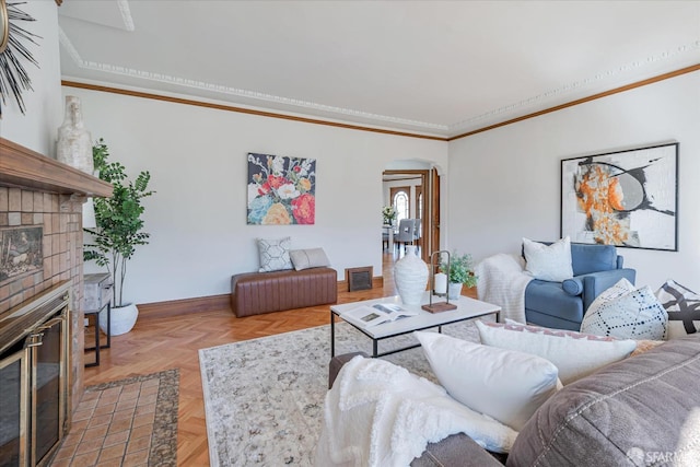 living room featuring baseboards, visible vents, arched walkways, crown molding, and a fireplace