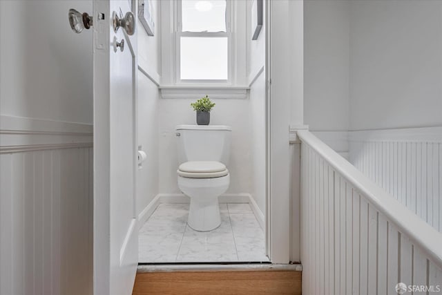 bathroom with baseboards and toilet