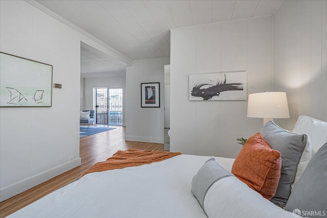 bedroom featuring wood finished floors and a decorative wall