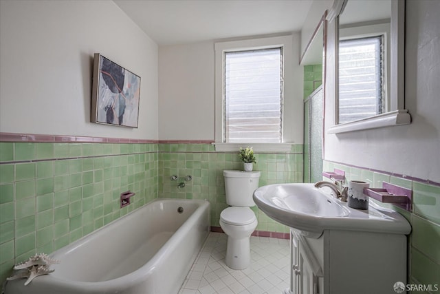 bathroom with tile walls, vanity, a bath, and tile patterned floors